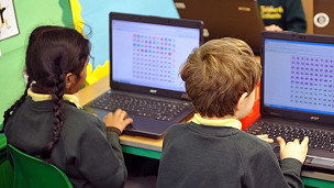 Dos niños utilizando computadoras.